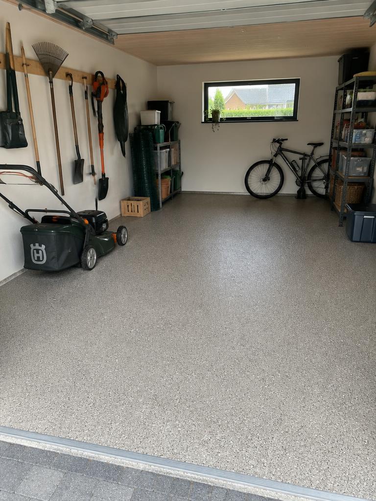 Gråt StoneCarpet-garagegulv med haveværktøj